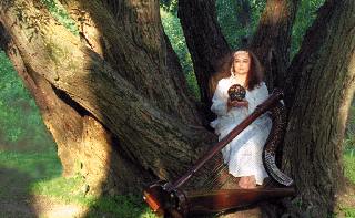 [photo of Jacquelyn in willow tree
holding Earth ball]